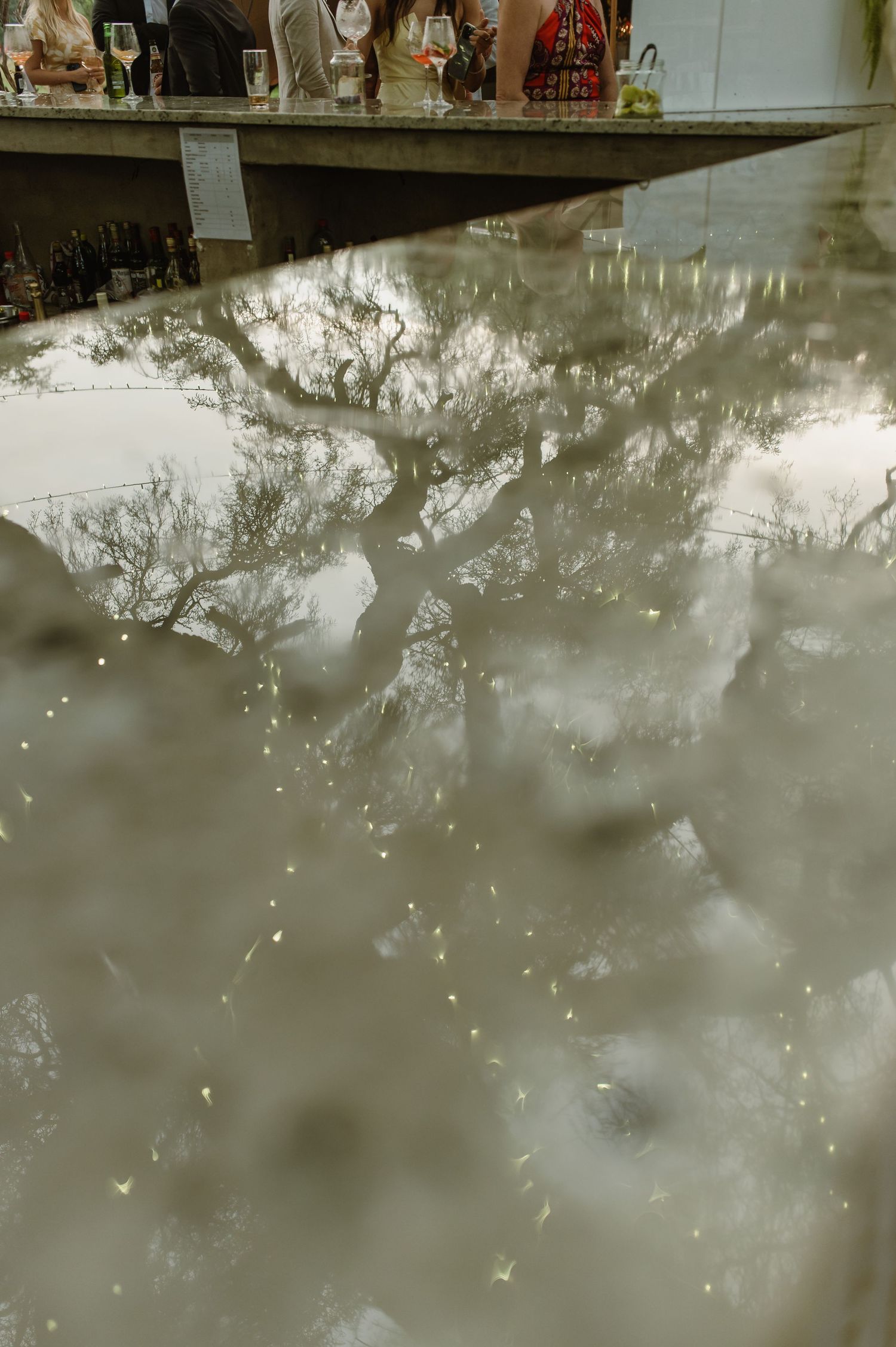 Abstract reflective water surface with blurred lights and shapes.