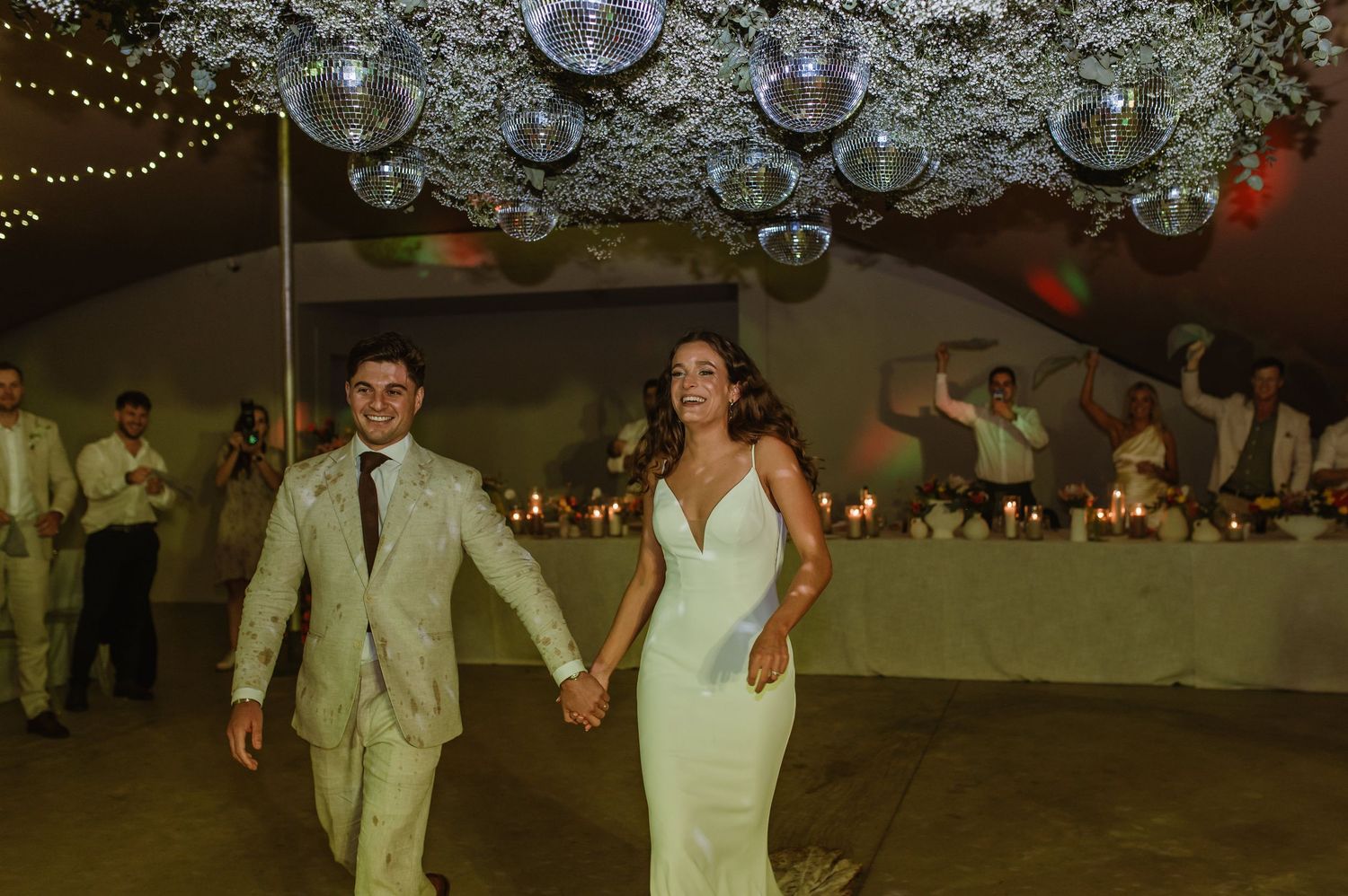 Disco balls and string lights create a festive atmosphere for wedding dancing.