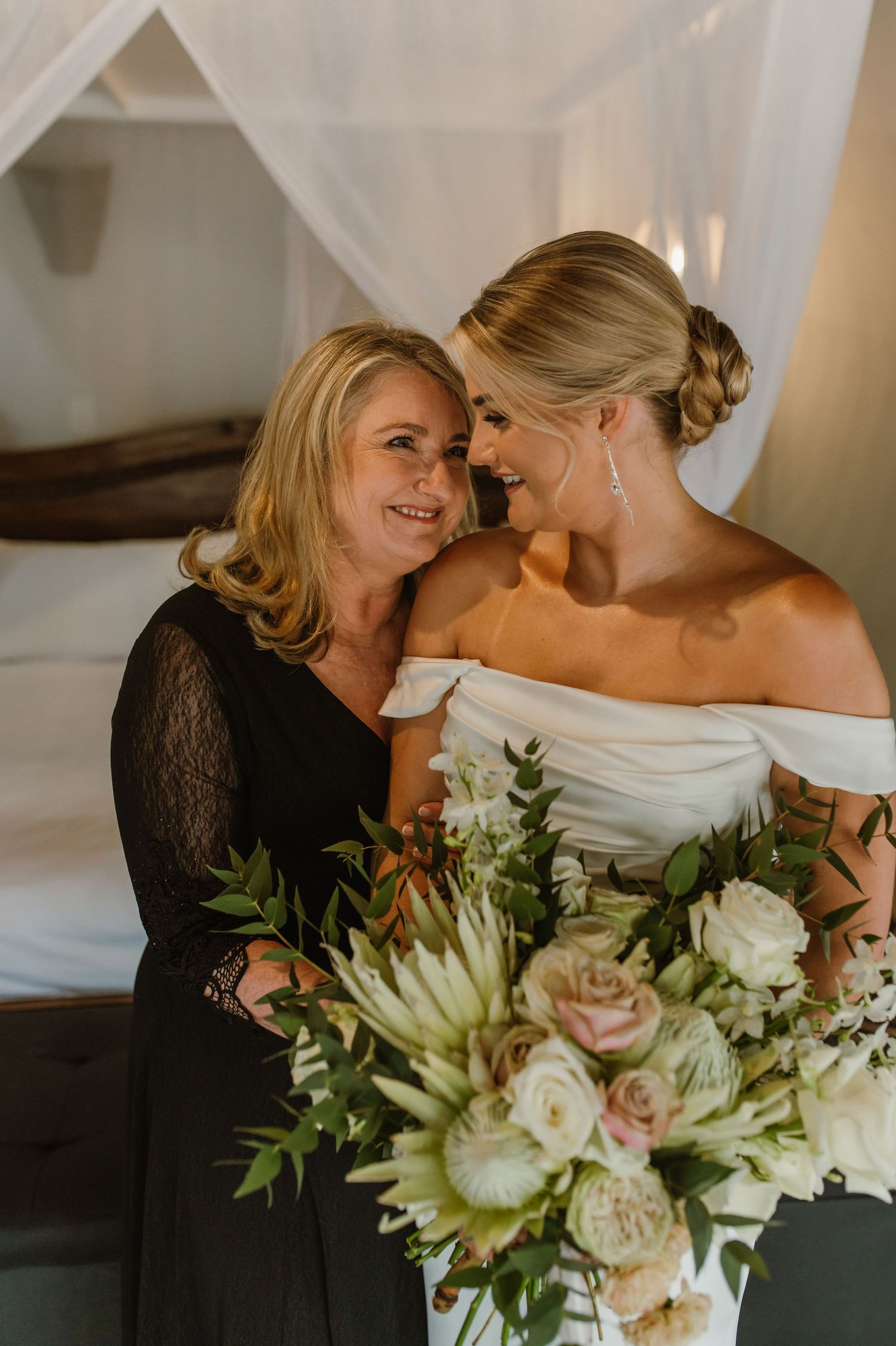 Emotional wedding moment with beautiful bouquet of white roses and greenery.