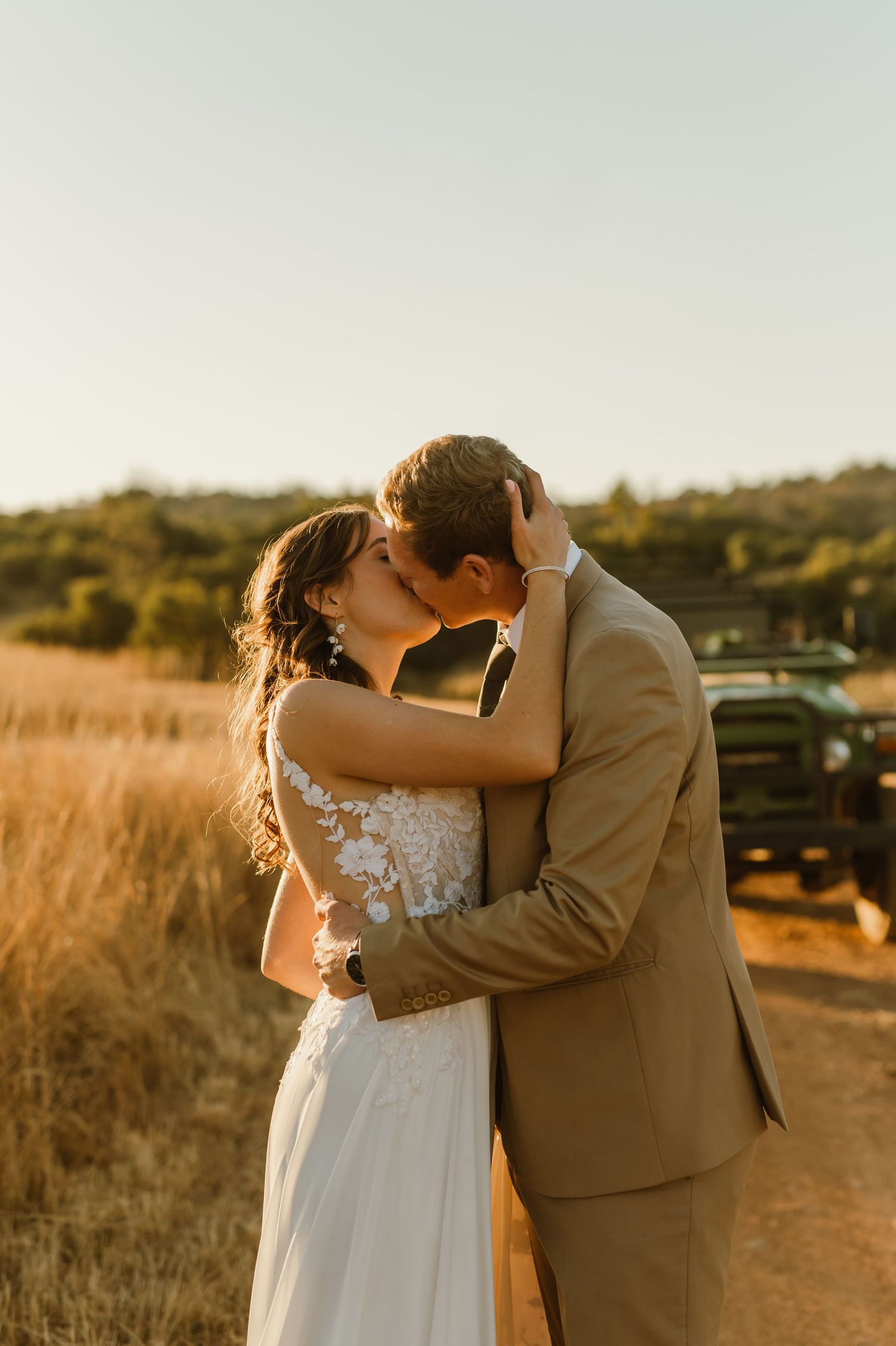 Romantic sunset moment between newlyweds on a rural dirt road.