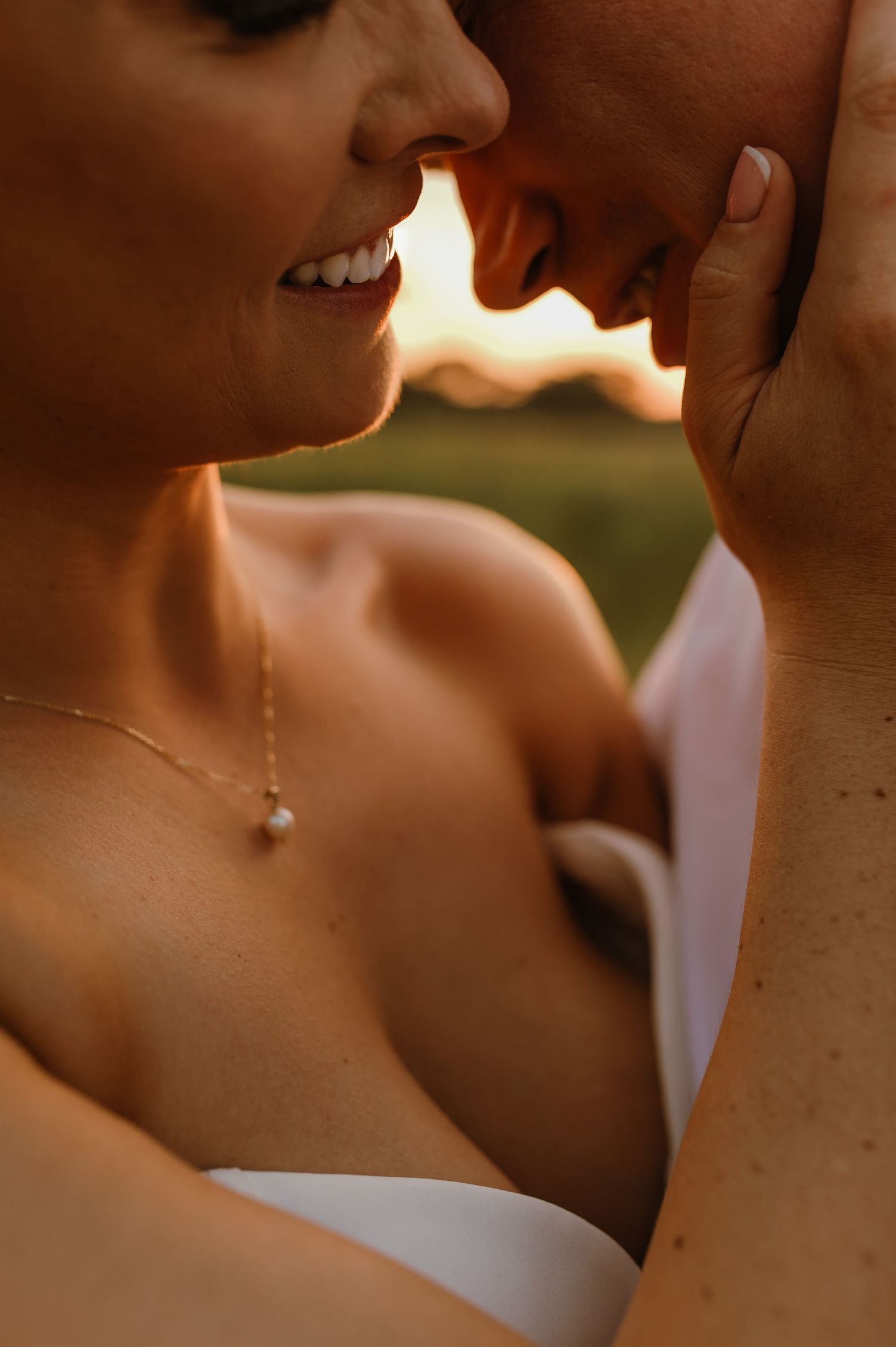 Close-up intimate portrait of a couple sharing a tender moment in warm sunlight.