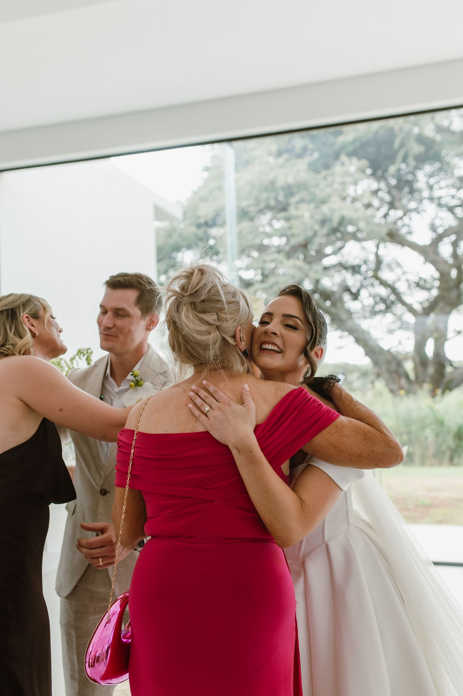Emotional celebration moment at an indoor event with people embracing in formal attire.