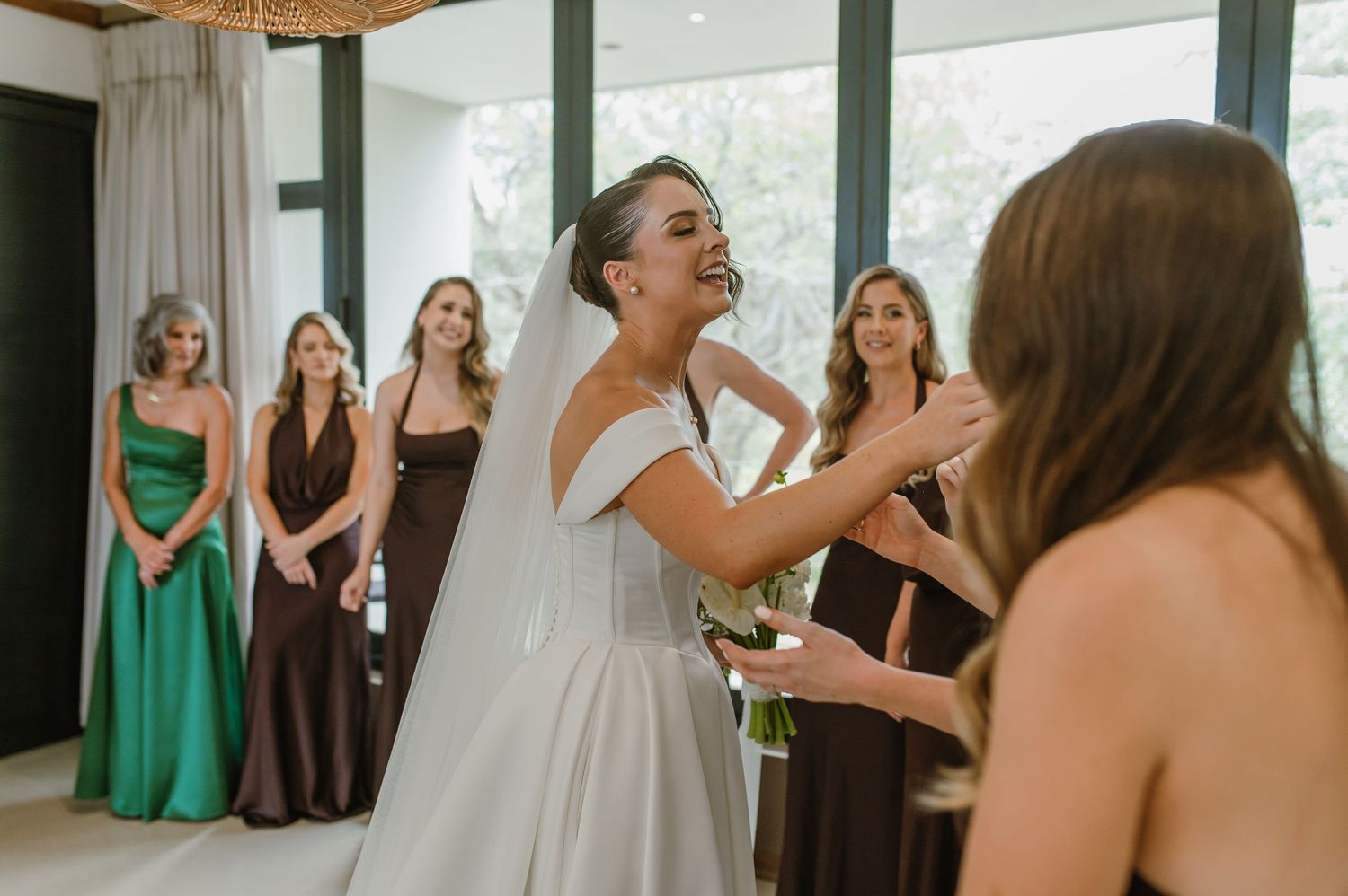 Wedding party celebrating in bright indoor venue with floor to ceiling windows.