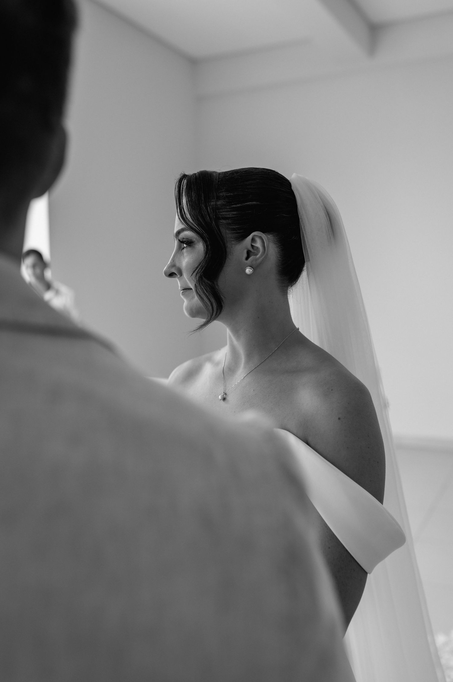 Black and white artistic wedding portrait captured in dramatic side lighting.
