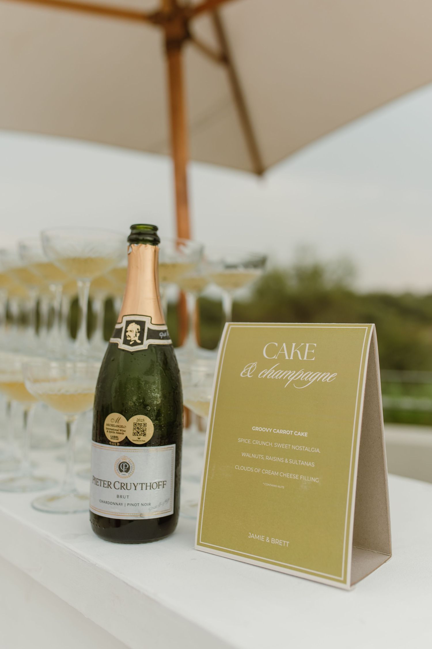 Champagne bottles and elegant gold table cards displayed at an upscale event setting.