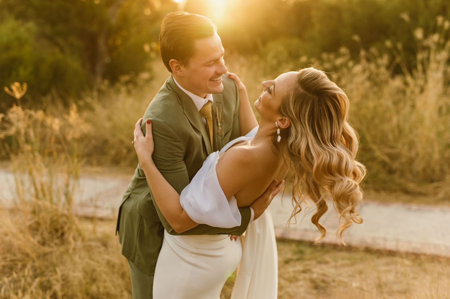 A romantic sunset photoshoot captures a couple dancing in warm golden light.