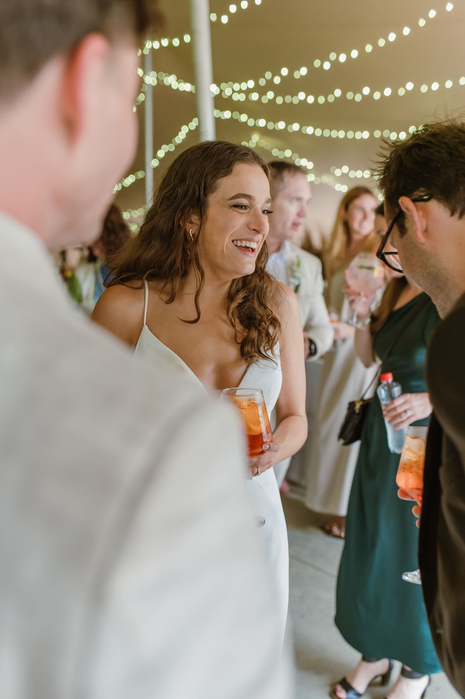 Candid moments of joyful celebration captured under string lights at an indoor event.