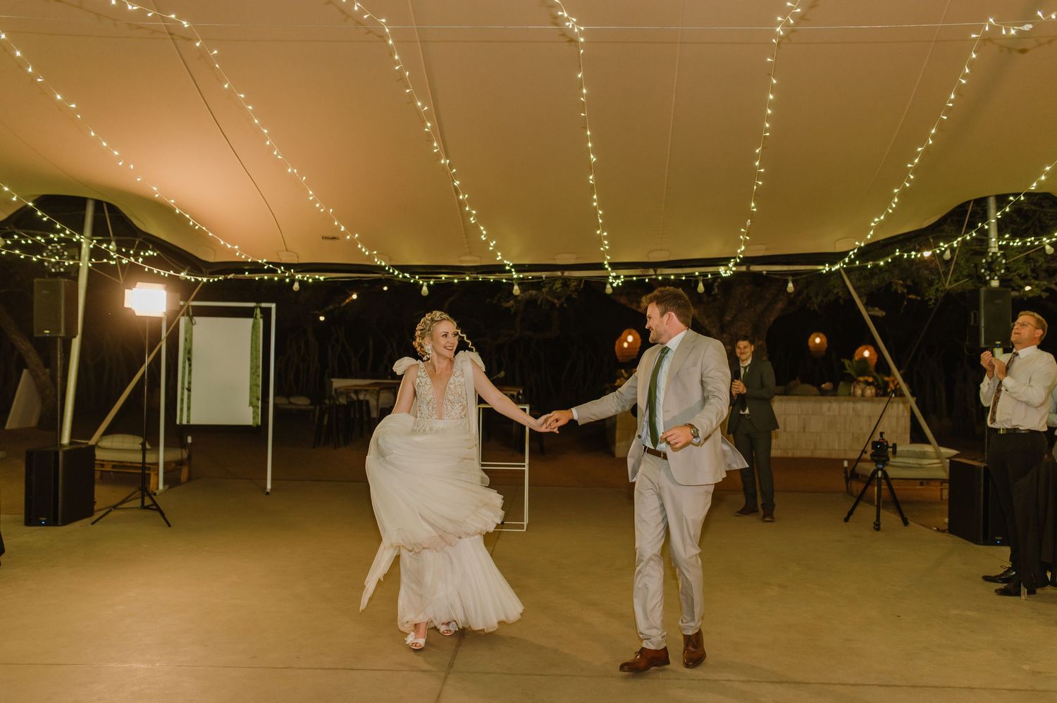 Wedding reception dance floor with string lights creating magical atmosphere.