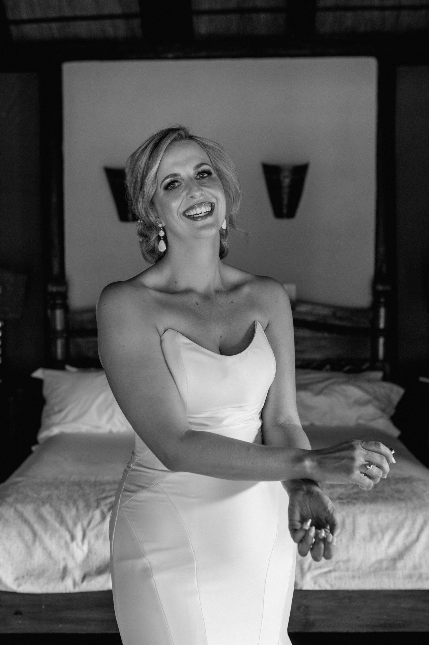 Black and white portrait of joyful bridal moment in rustic setting.