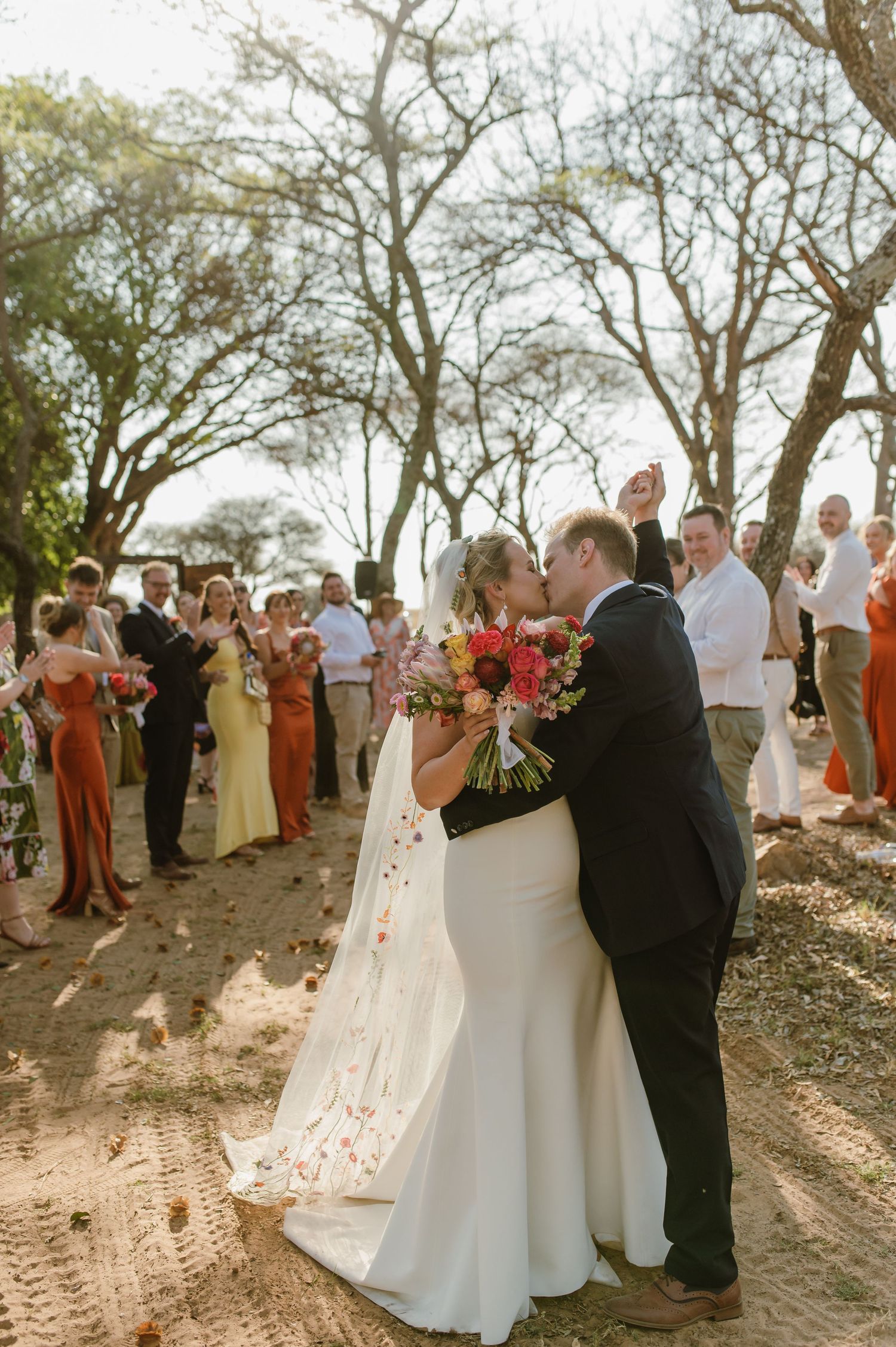 Couple shares their first dance surrounded by guests at an outdoor wedding reception.
