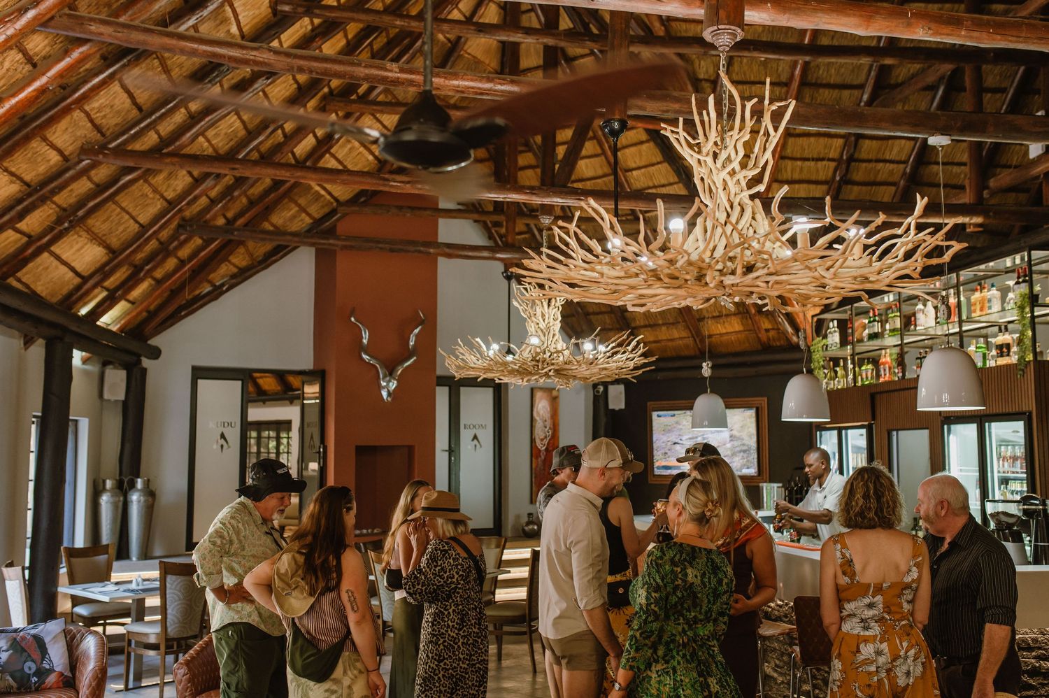 Interior of a rustic restaurant venue with exposed wooden beams and chandeliers.