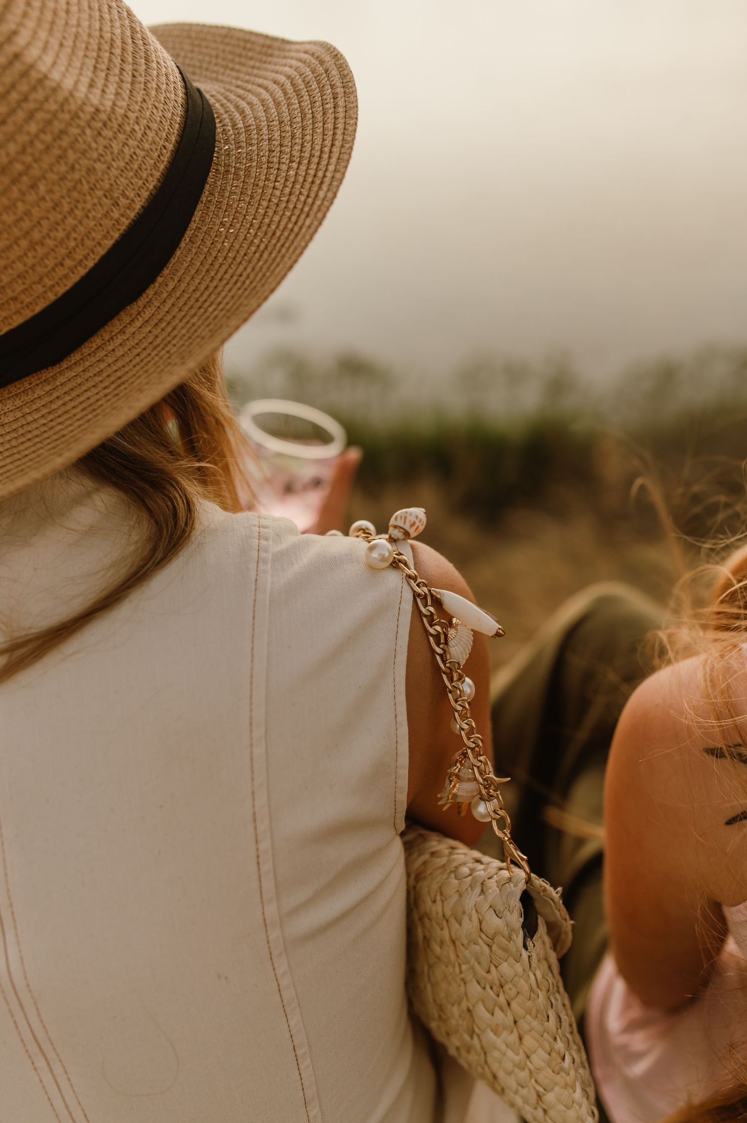 Person wearing a straw sun hat against a warm sunset backdrop.
