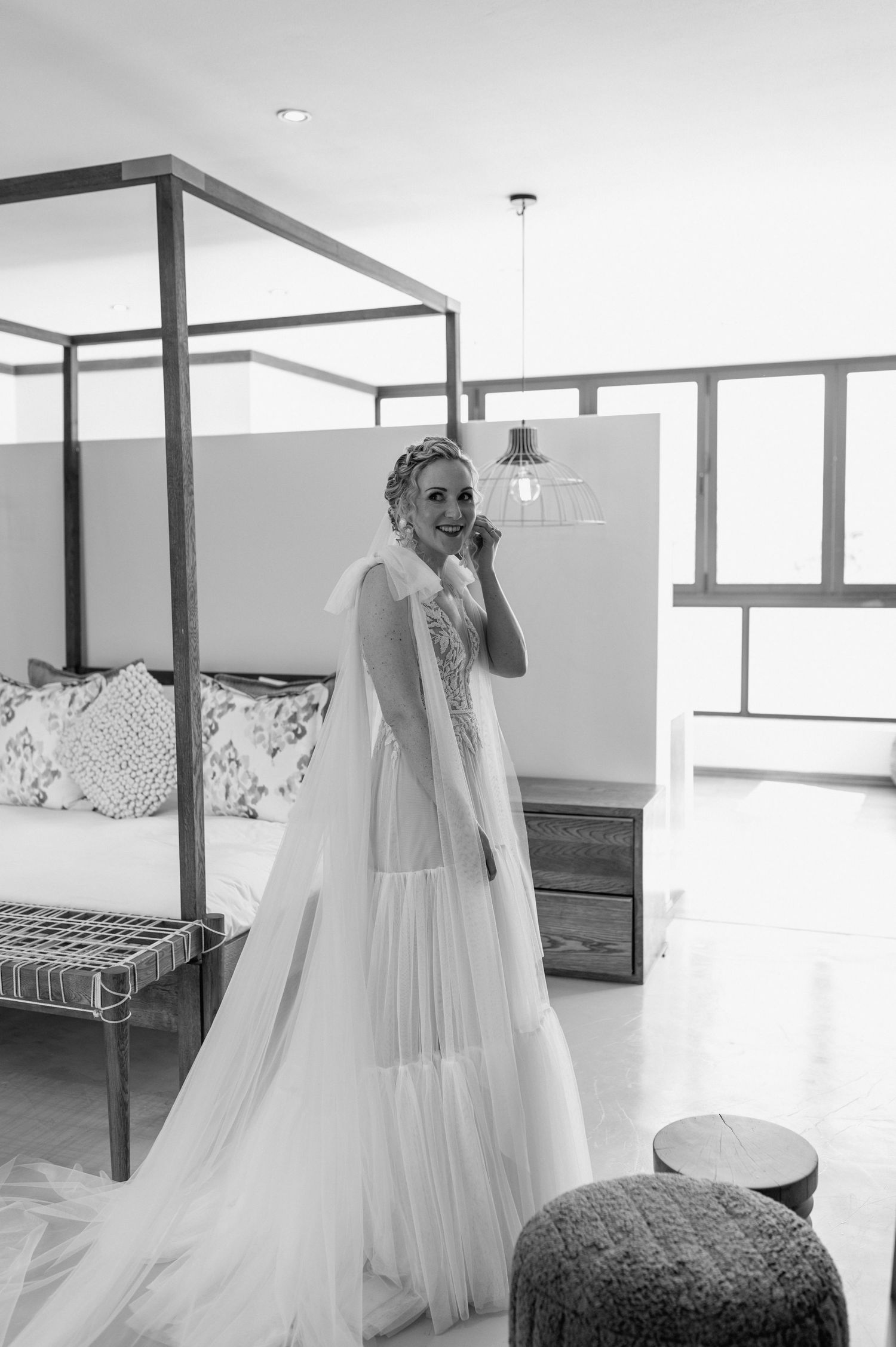 Black and white photo of wedding dress and veil in modern interior setting.