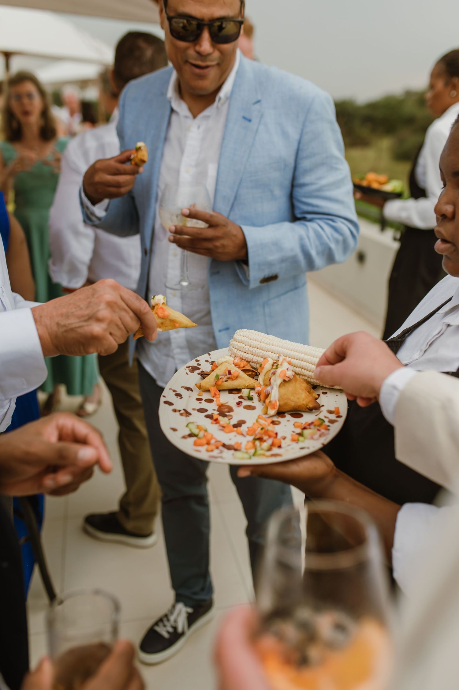 Guests enjoying appetizers at an outdoor reception while mingling.
