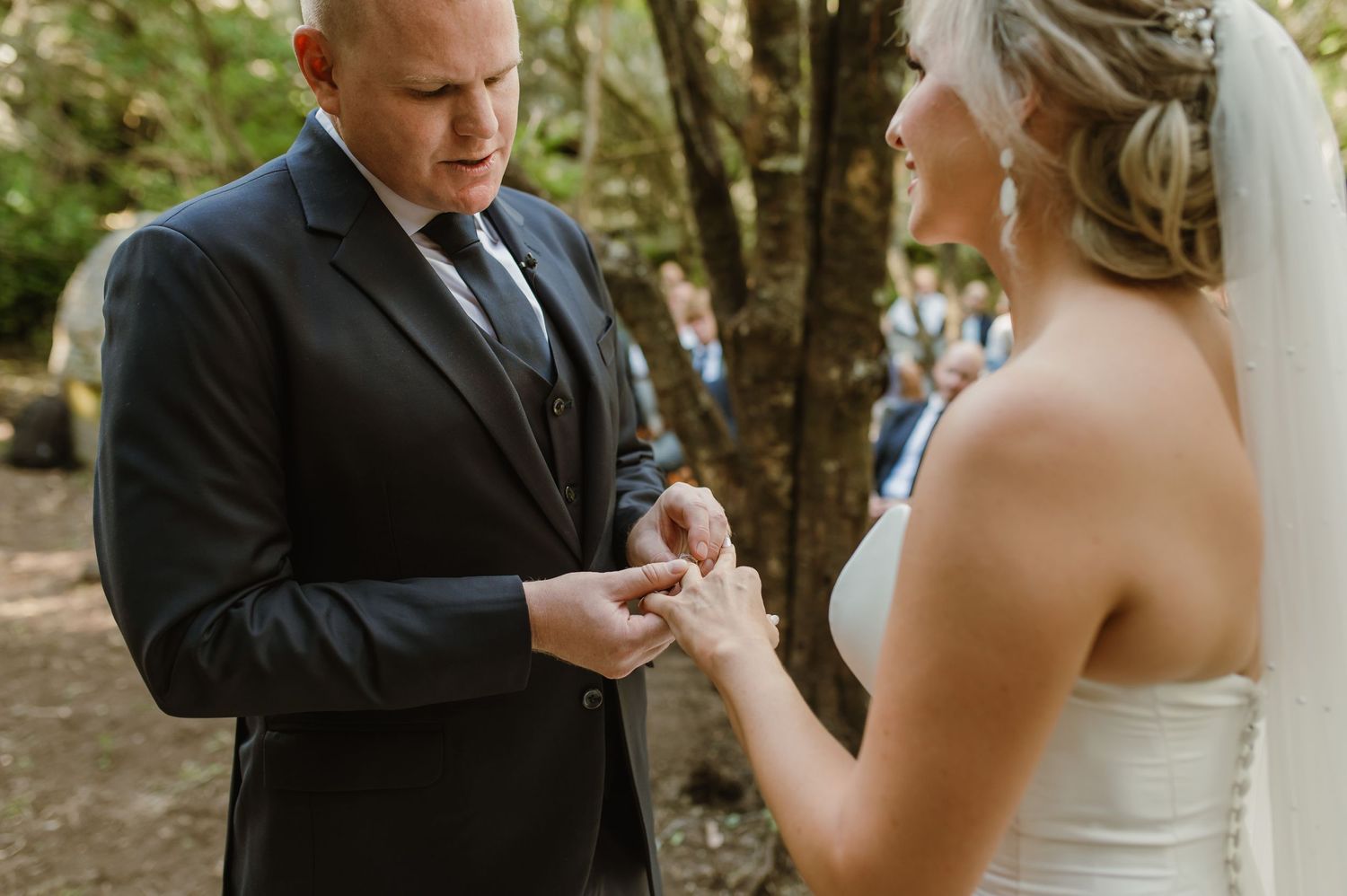 Emotional wedding ceremony moments captured in a natural forest setting.
