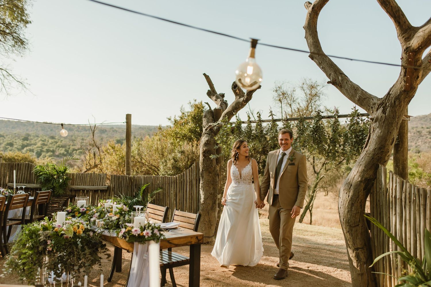 Wedding ceremony space decorated with white fabric and natural elements in a desert setting.