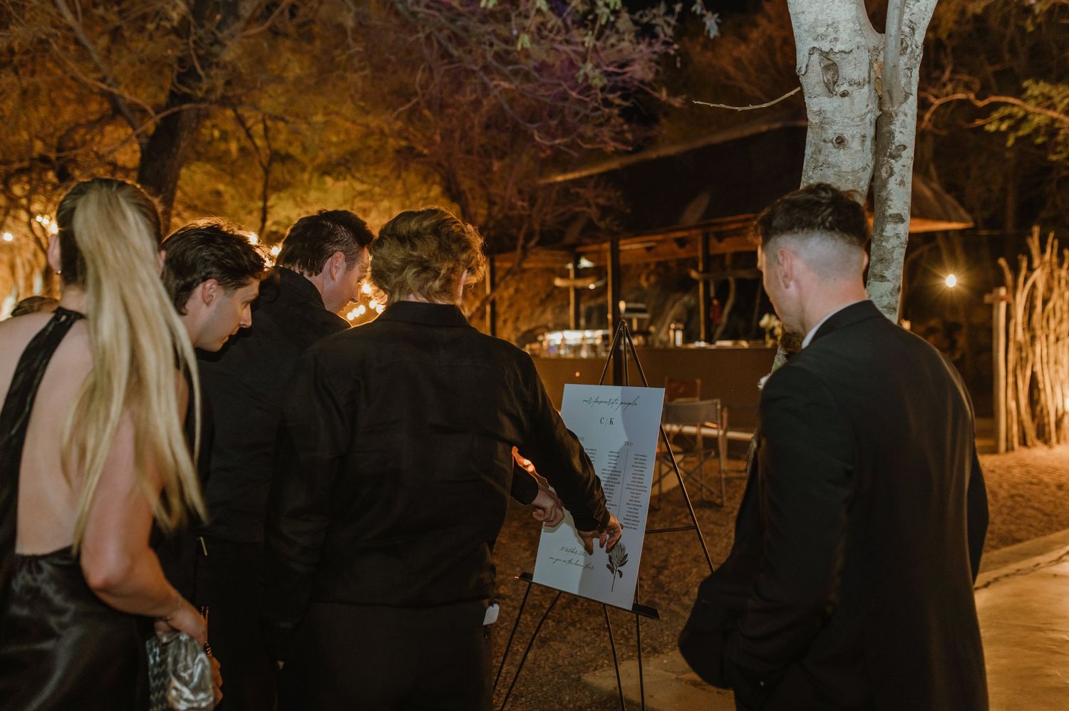 Evening outdoor celebration with formal attire and atmospheric lighting.