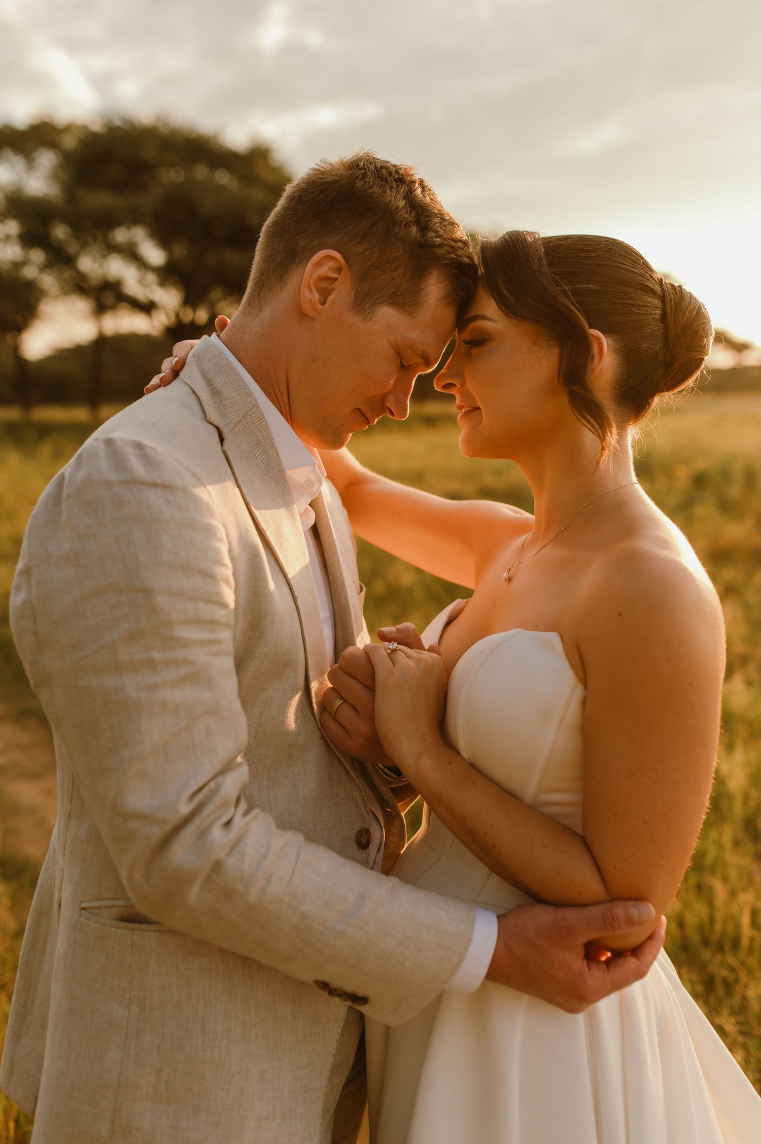 A romantic wedding photoshoot captures intimate moments between newlyweds in warm sunset lighting.