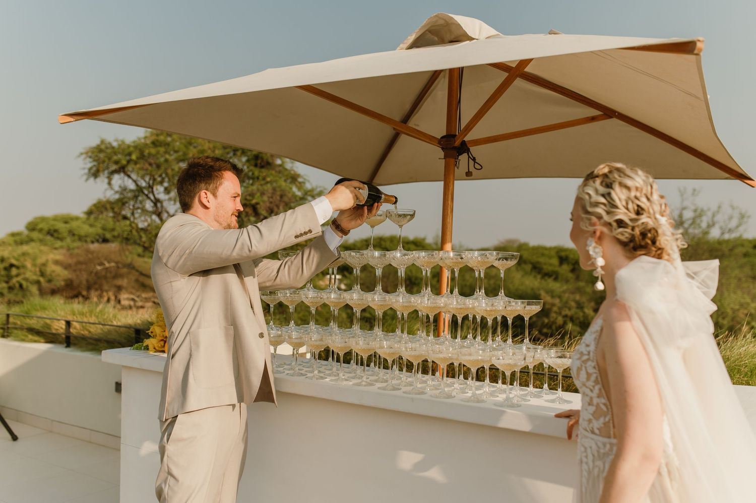 Couple sharing champagne during sunset on an outdoor terrace.