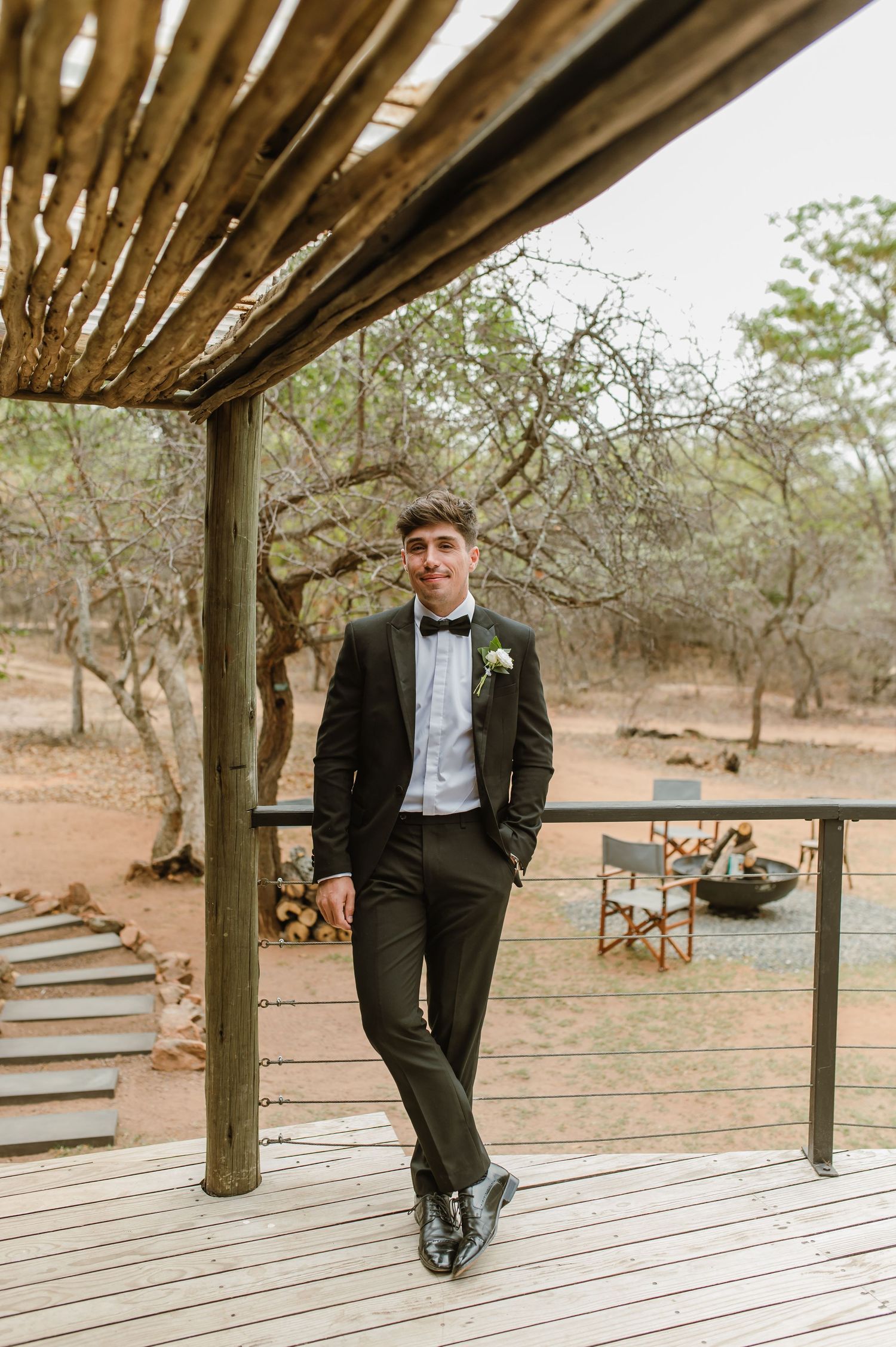 Stylish formal portrait on wooden deck with rustic wooden beams and natural landscape.