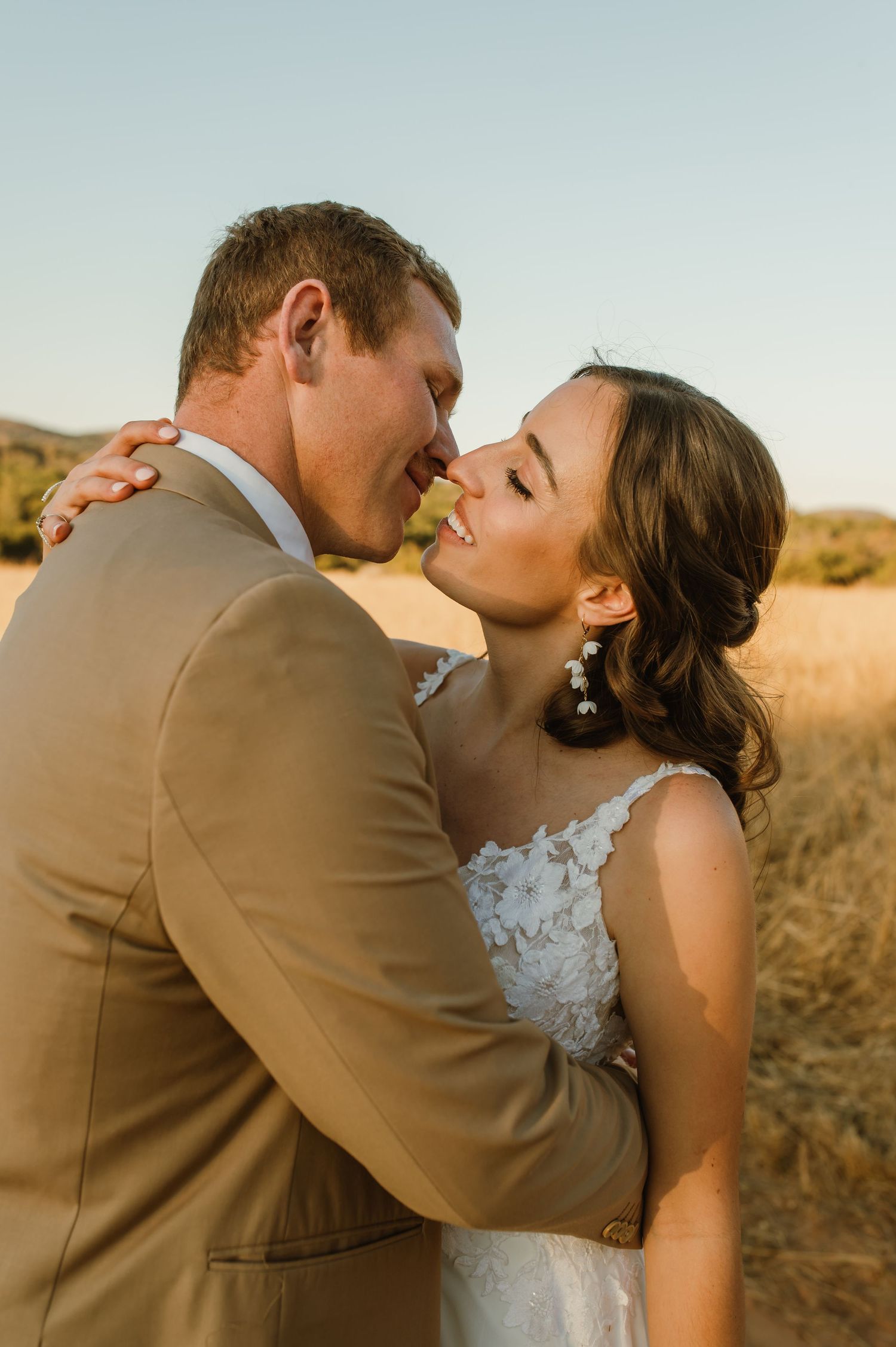 Close-up of wedding couple sharing tender moment in warm evening light.