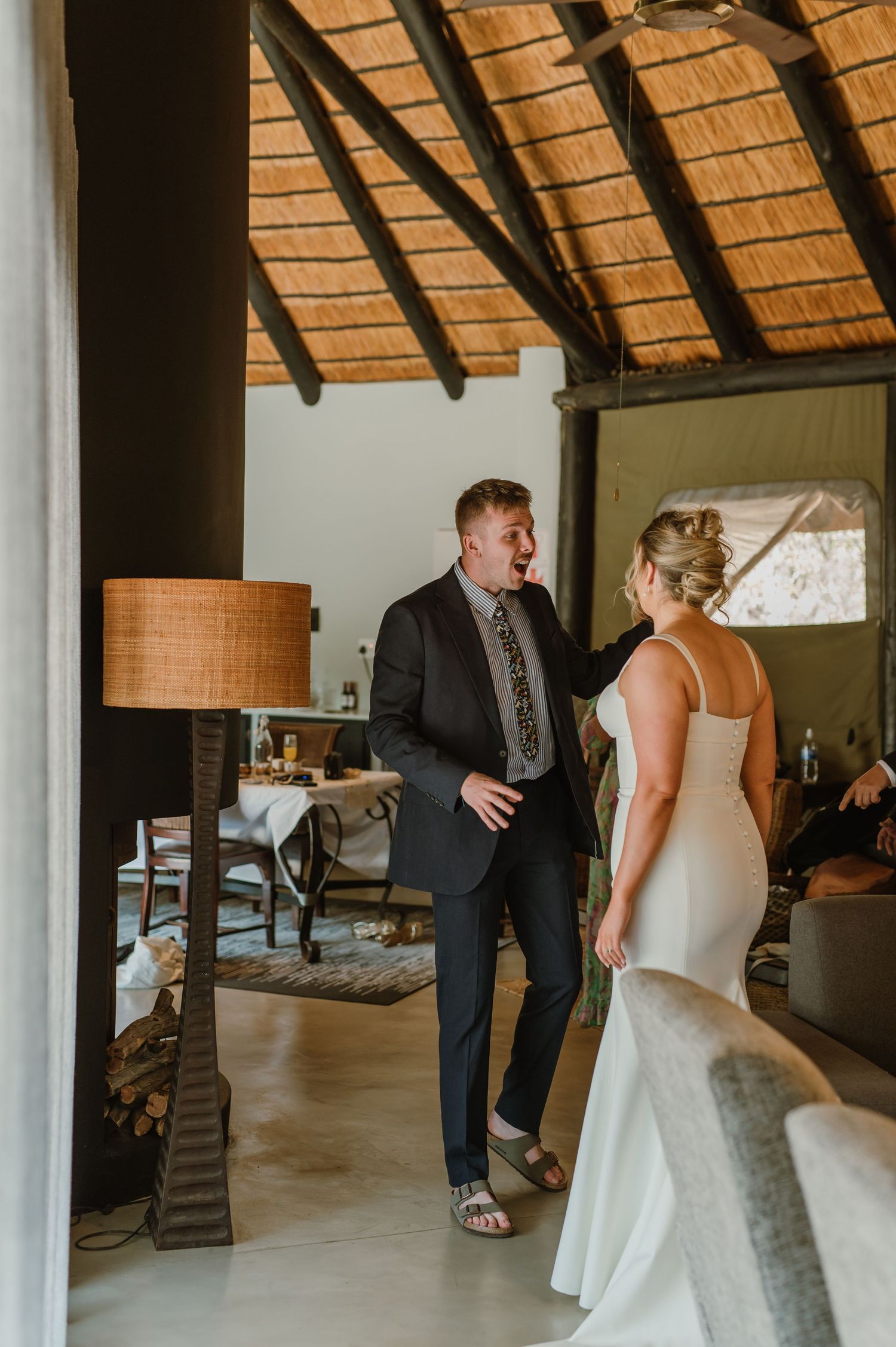 Emotional first look between wedding couple in rustic venue with wooden beams.