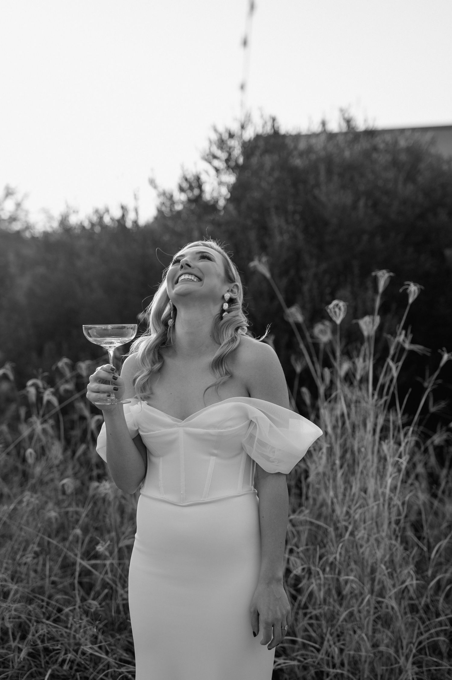 Black and white portrait of a bride laughing joyfully during her wedding celebration.