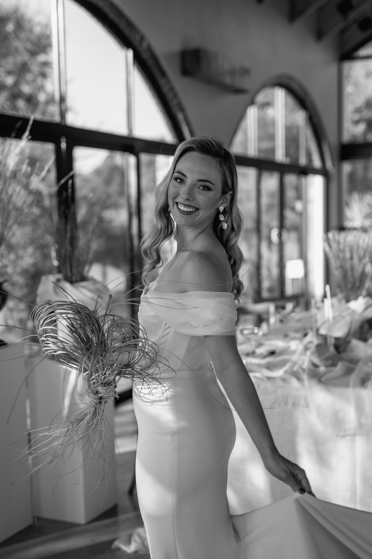 Elegant bridal portraits in a light-filled venue with arched windows.