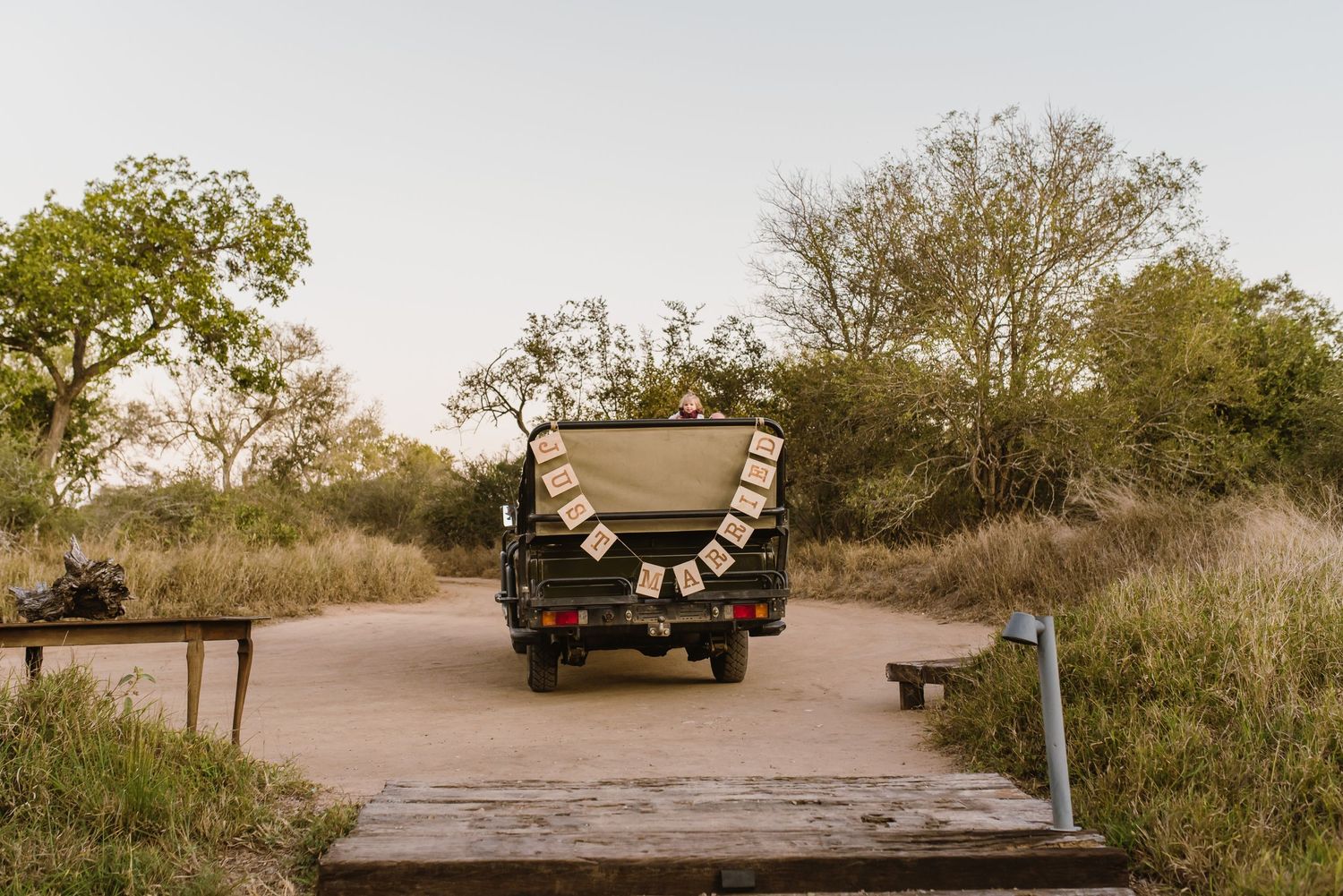 Scenic beach wedding setup with guests seated along a sandy pathway at dusk.