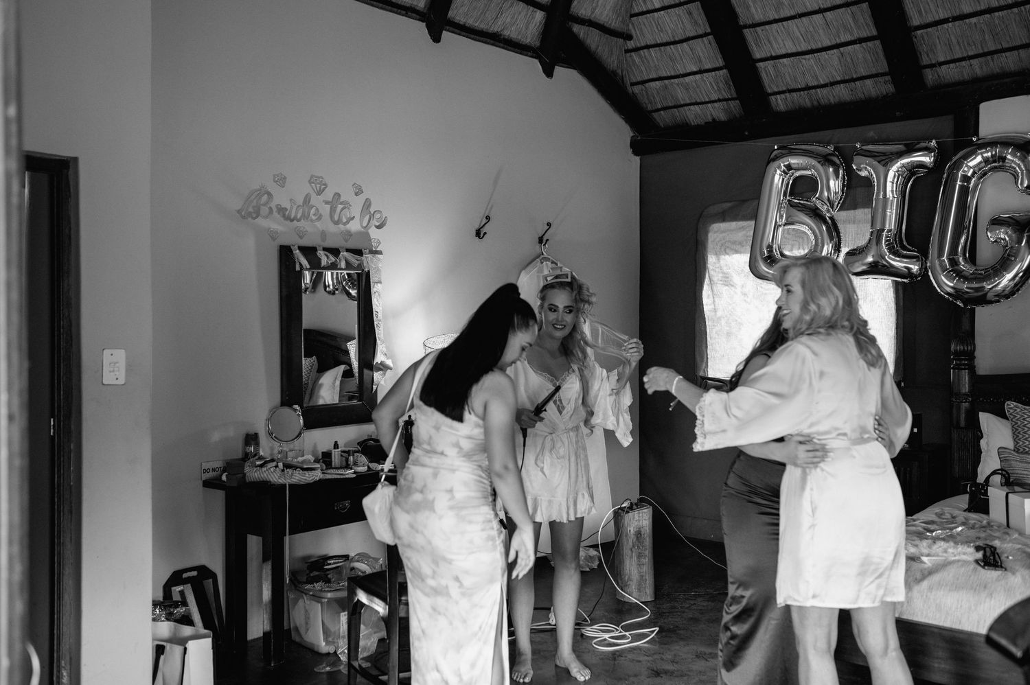 Black and white photo of wedding preparations in a room with natural light.