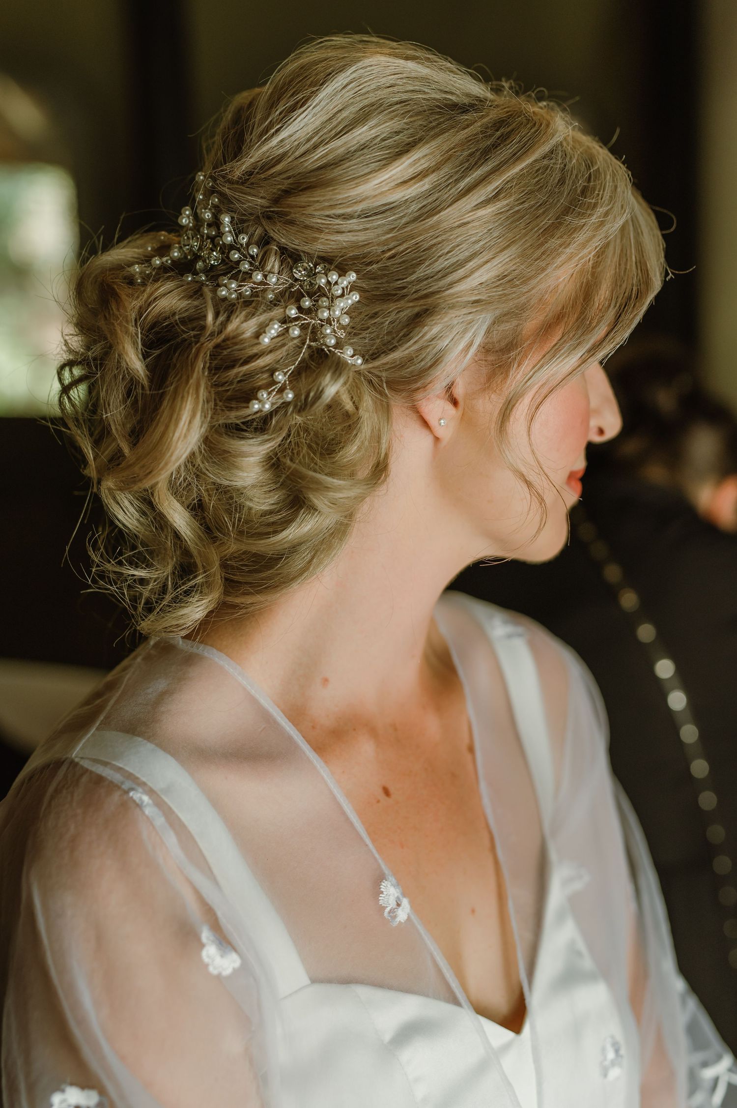 Close-up of elegant bridal hairstyle with delicate floral hair accessories and blonde updo.