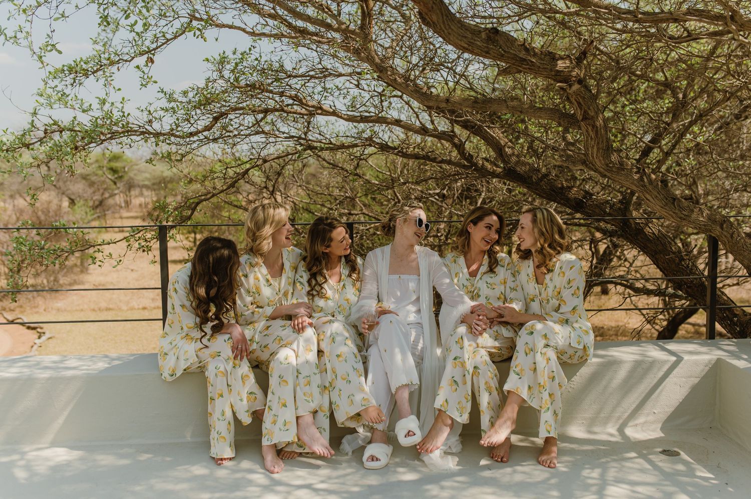 Candid shots of bridal party relaxing outdoors in matching floral robes.
