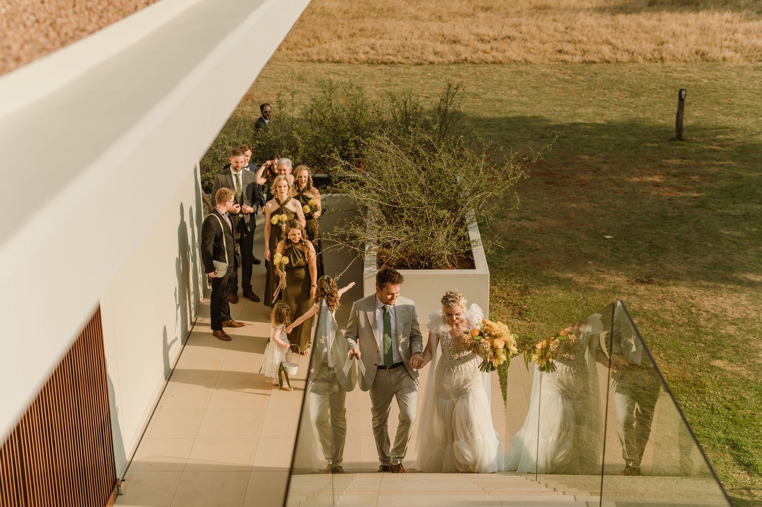 Wedding guests walking along an outdoor pathway during sunset.