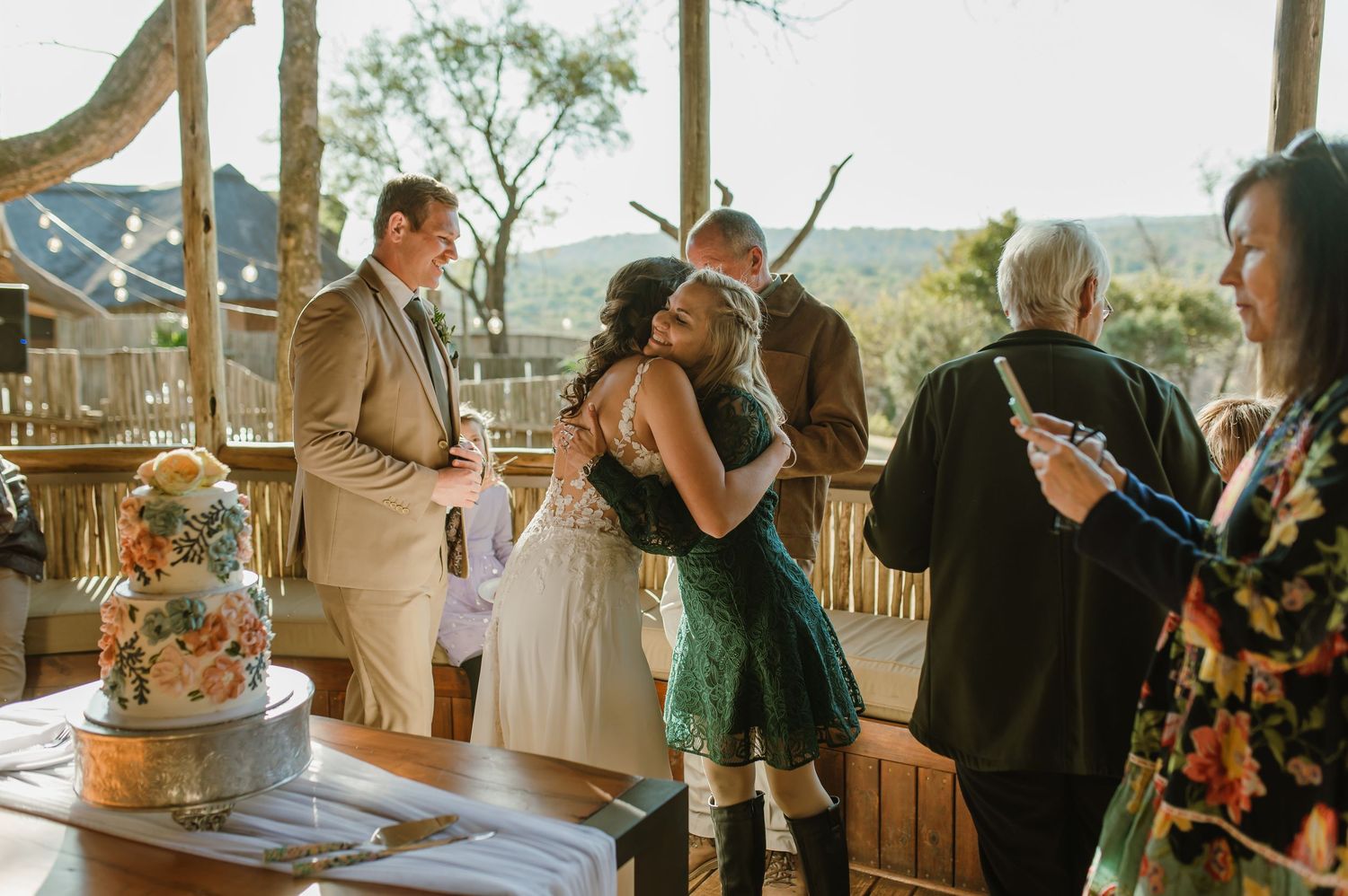 Outdoor wedding venue with wooden pavilion and scenic mountain views in the background.