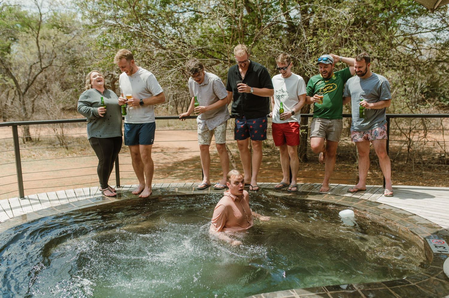 People enjoying a refreshing swim in a natural rock pool surrounded by lush vegetation.