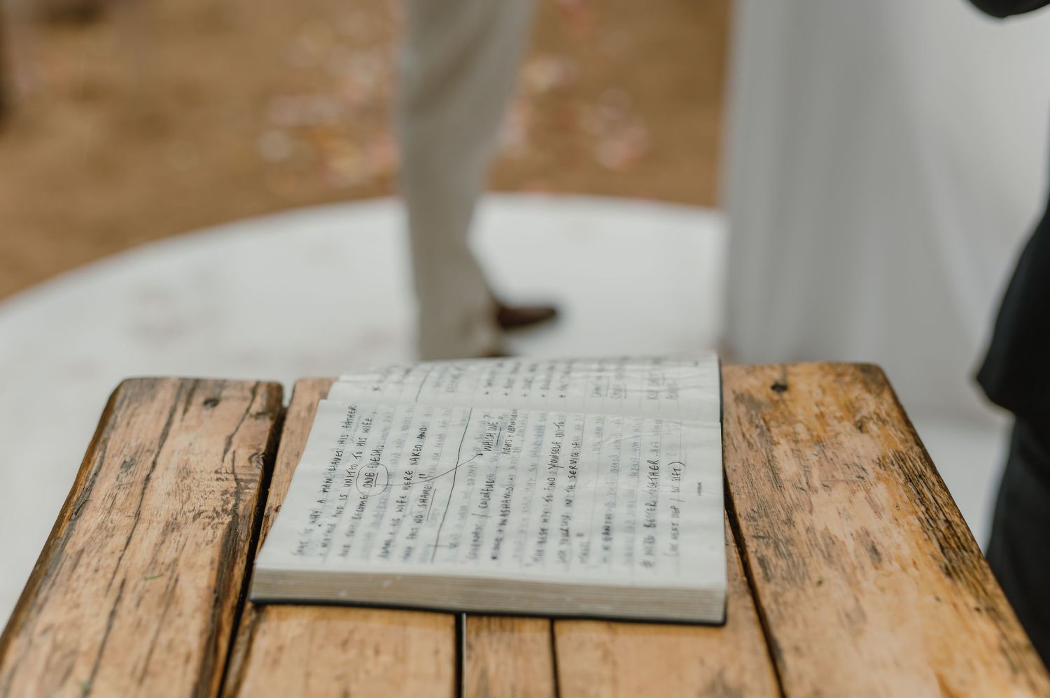 Close-up of handwritten wedding vows on rustic wooden surface.