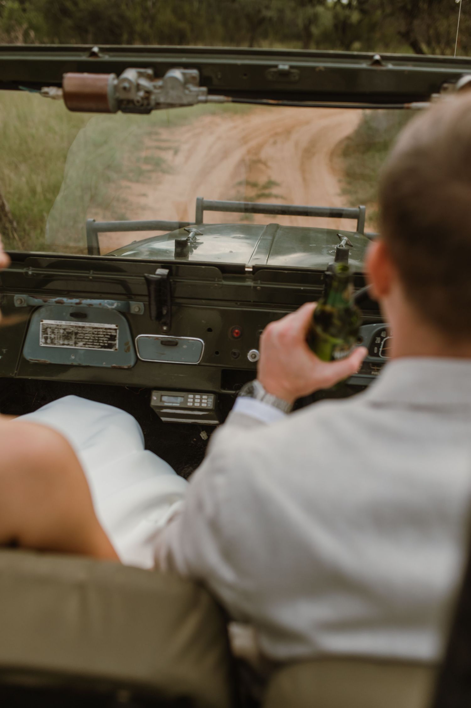 Interior view of a vintage car dashboard and steering wheel with hands on the wheel.