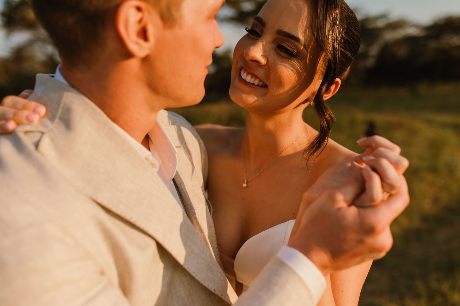 A tender moment between newlyweds during golden hour in a natural outdoor setting.