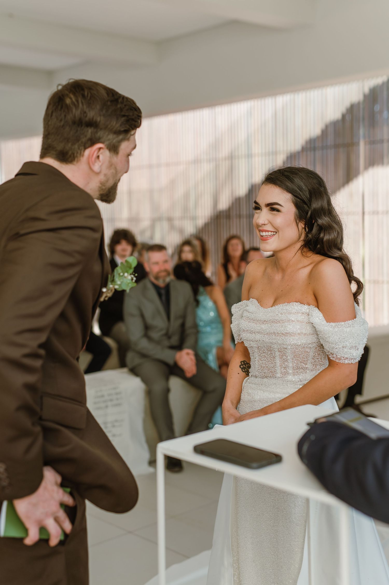Emotional first look moment between couple during wedding ceremony in bright indoor space.
