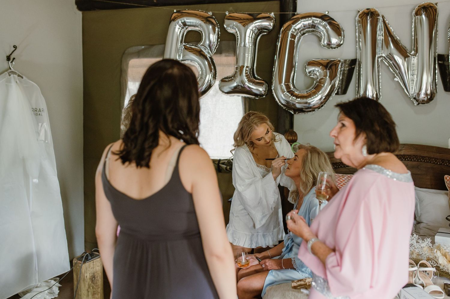 Bridal party celebrating with silver balloon decorations in background.
