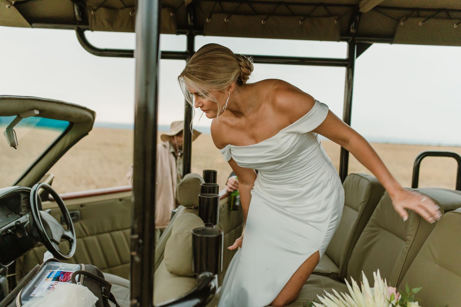 Wedding couple shares joyful moments inside a vintage safari vehicle.