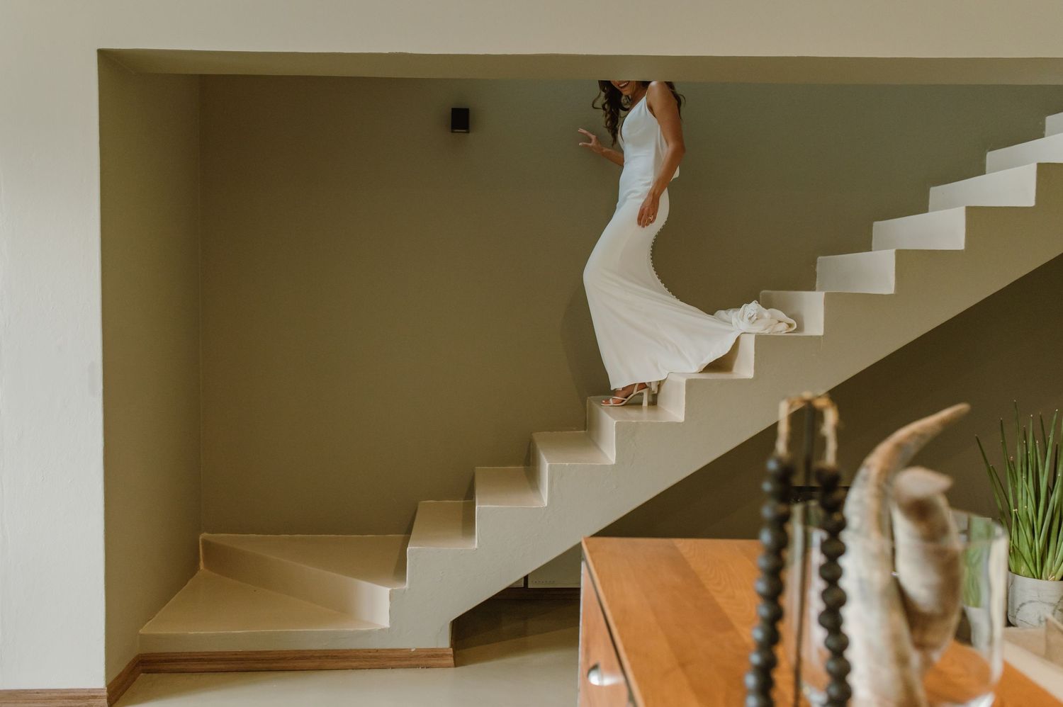 A modern staircase leads upward in an elegant interior with natural lighting.
