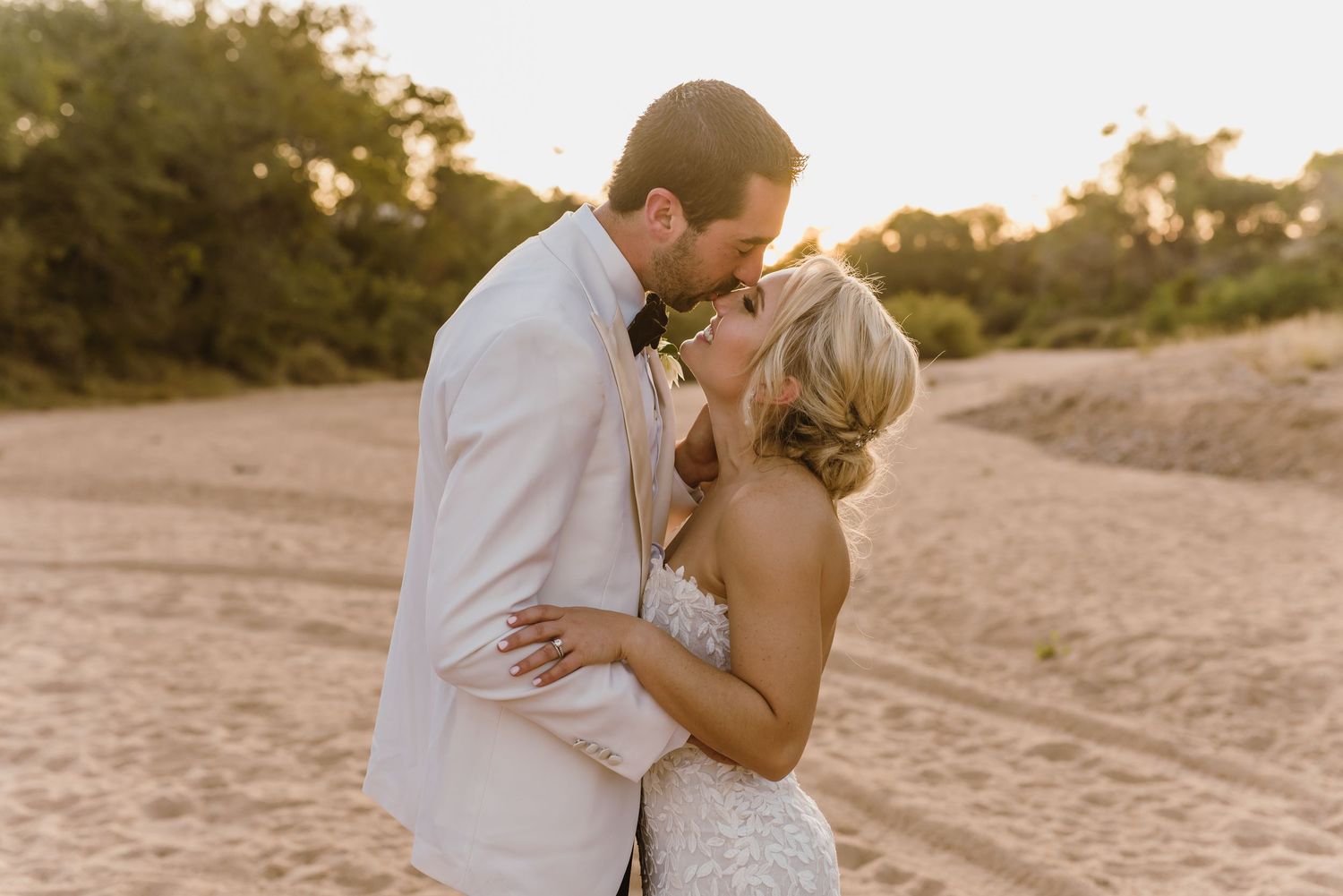 Romantic sunset photoshoot on a sandy beach with golden hour lighting.