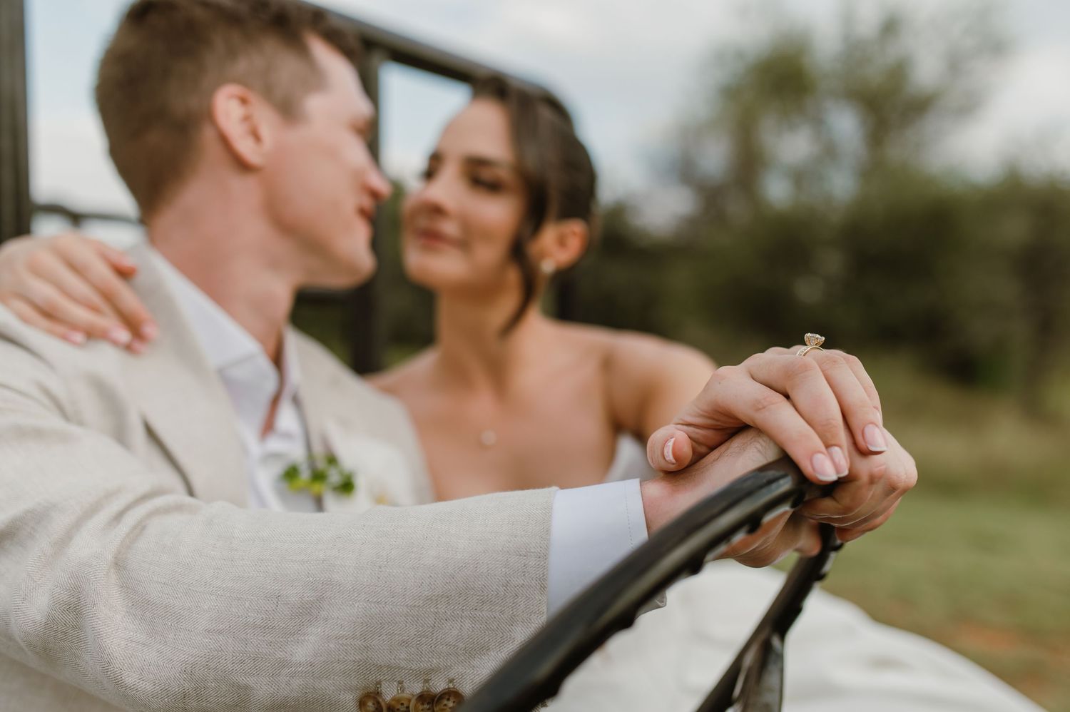 Close-up of a couple's tender embrace during a romantic outdoor wedding photoshoot.