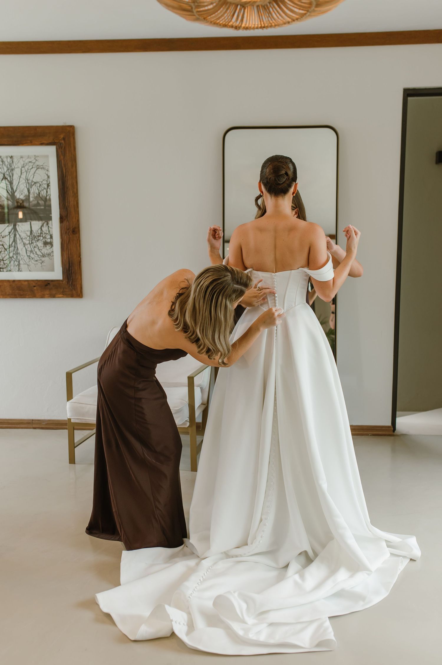 A series of photos showing a wedding dress being put on with assistance from someone wearing a brown dress.