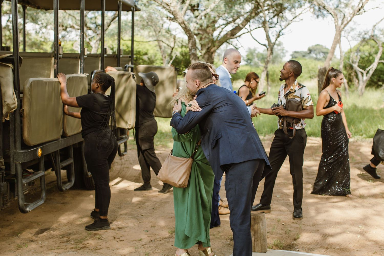 Guests mingling at rustic outdoor wedding venue with wooden barrels.