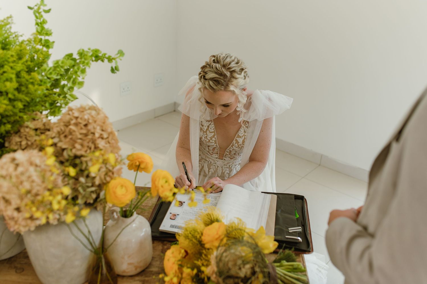 Wedding ceremony details with yellow sunflower arrangements and modern white decor.