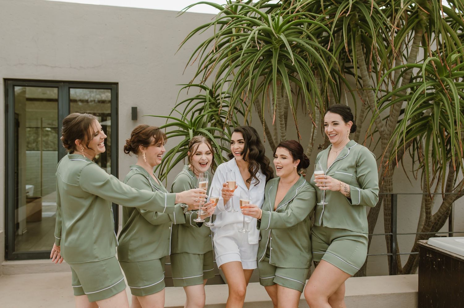 People in matching green outfits celebrating on an outdoor patio.