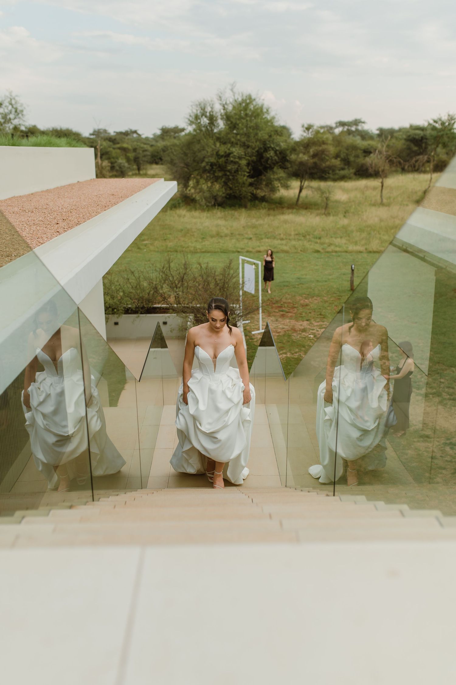 Creative wedding party photo featuring reflective mirror panels arranged outdoors in a natural setting.