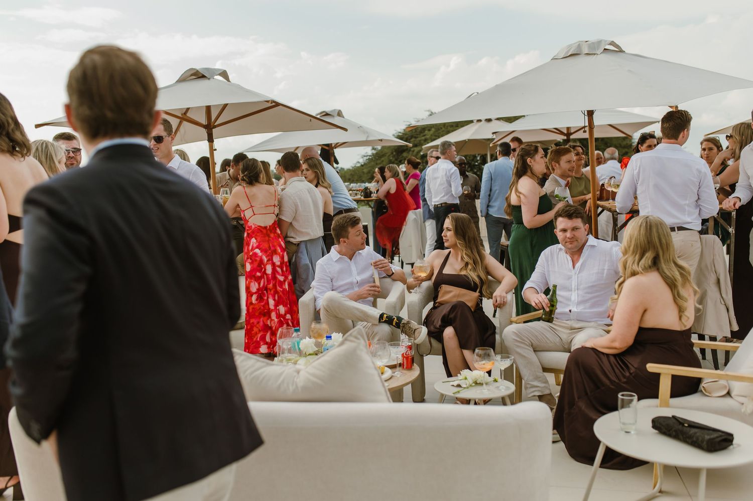 Outdoor wedding reception setup with white umbrellas and seating arrangements.